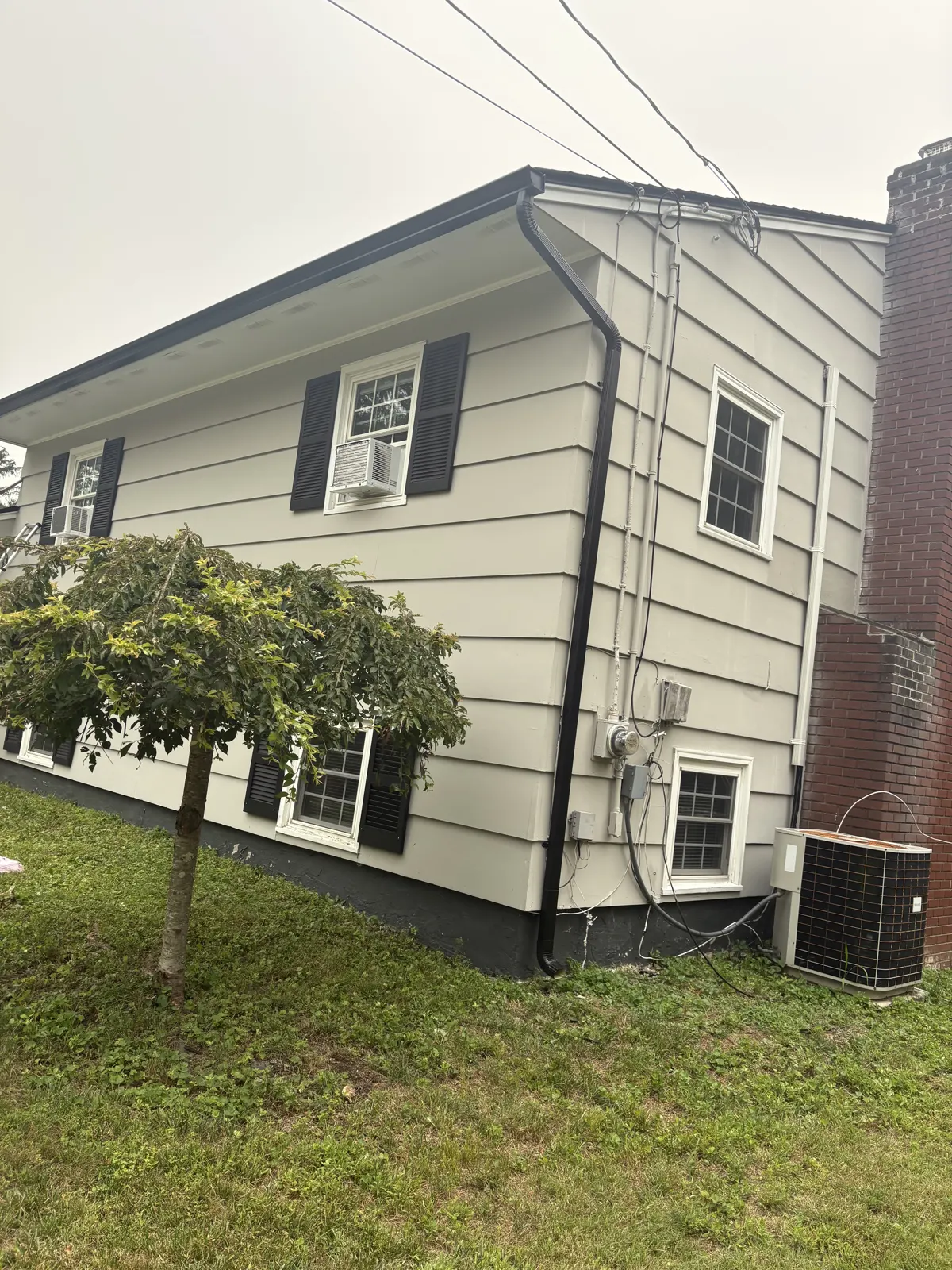 Cream lap siding with black shutters on a two-story home