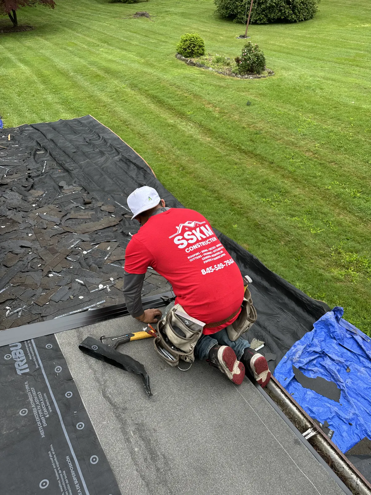 SSKM crew member installing underlayment on a roof tear-off
