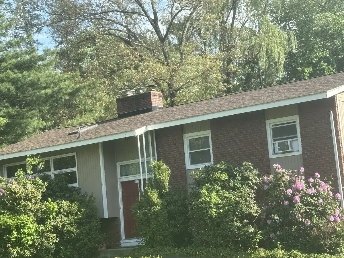 Brick ranch home with a brown shingle roof in Hyde Park, NY