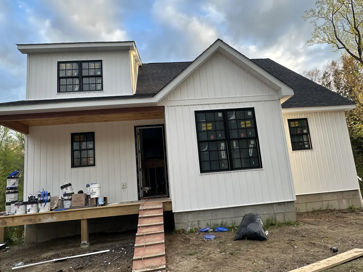 New construction home with a covered front porch and black-framed windows