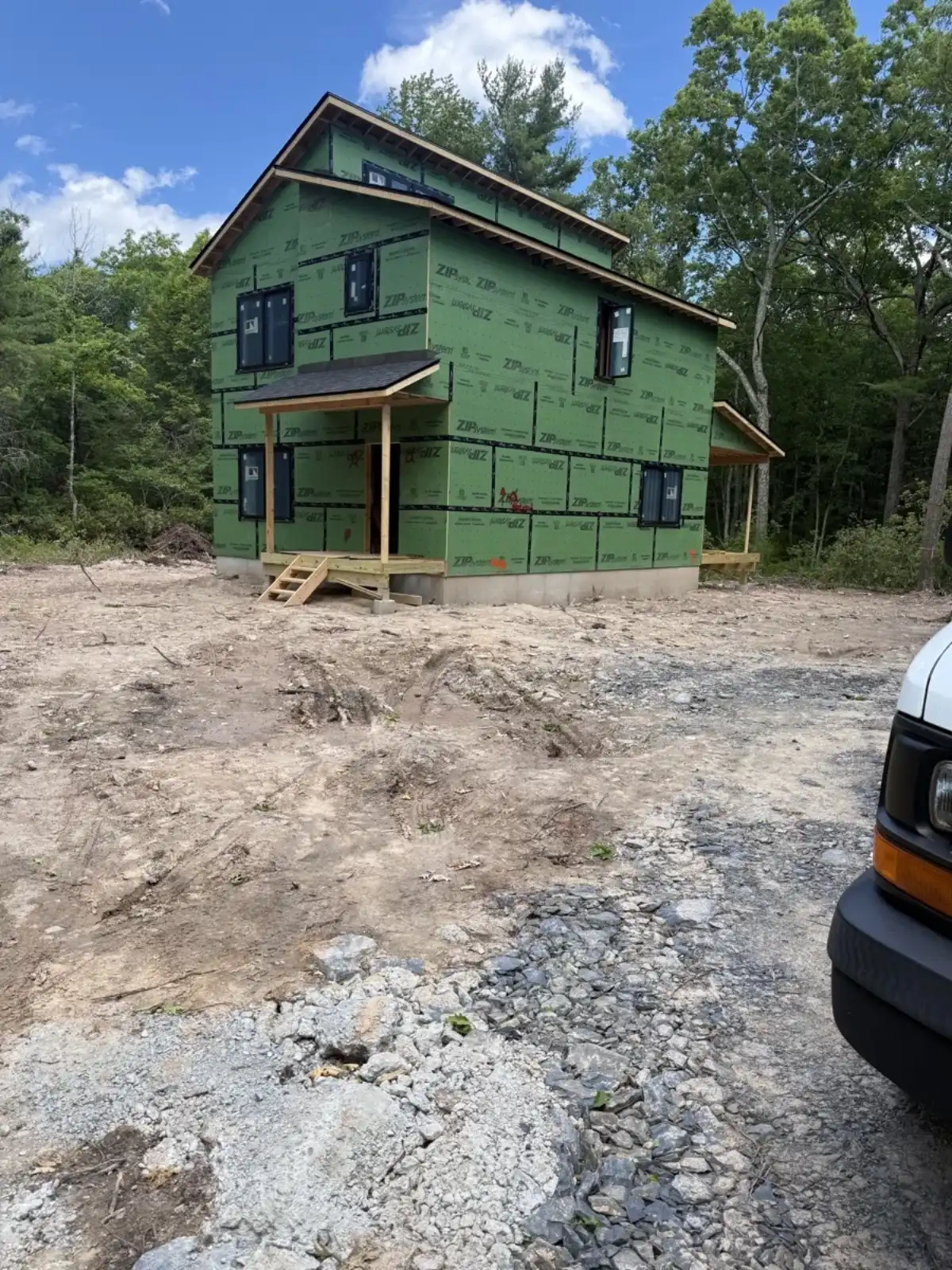 New construction framing wrapped in ZIP system sheathing on a wooded lot