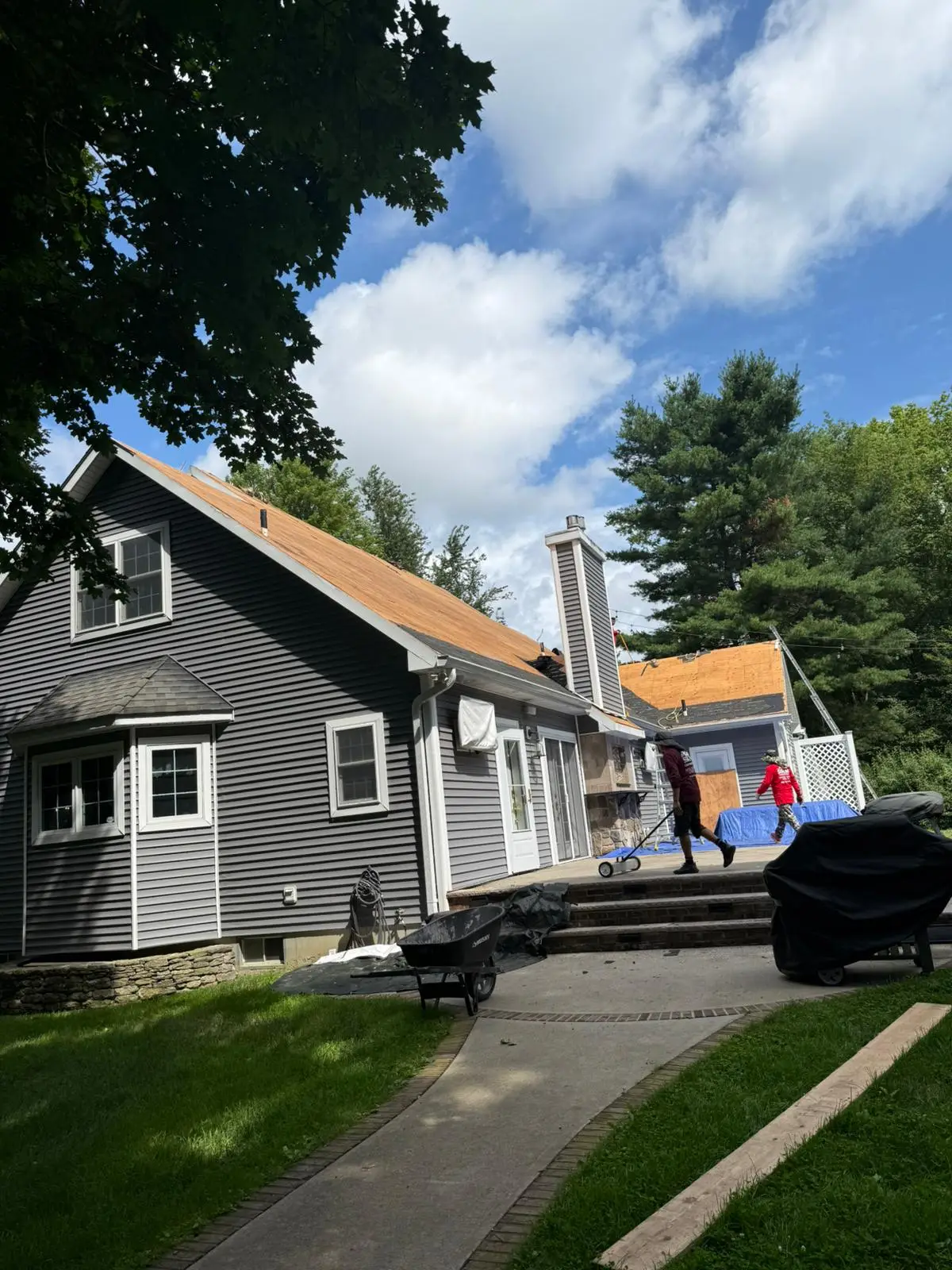 Crew sweeping the yard for stray nails during a roof re-deck